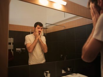 Tired man looking in the mirror